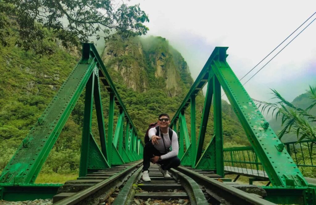 A hiker takes a picture by one of the bridges that connects Hidroeléctrica with Aguas Calientes.