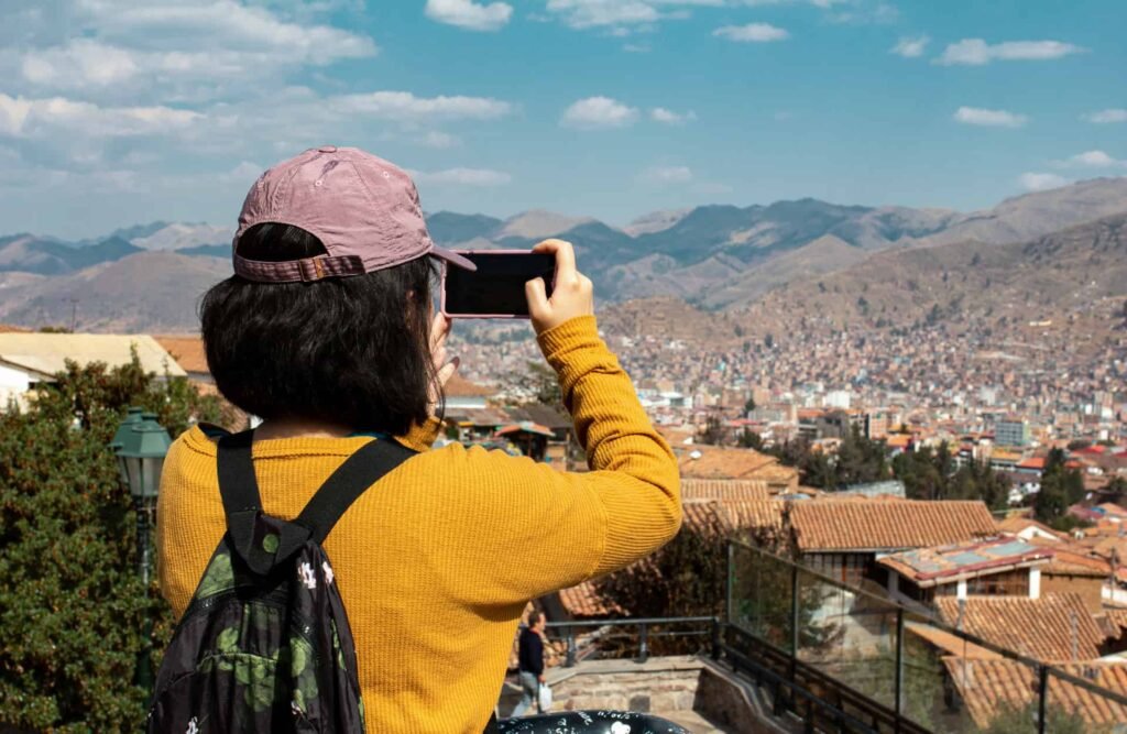 A tourist takes a photo of Cusco from San Blas's lookout.